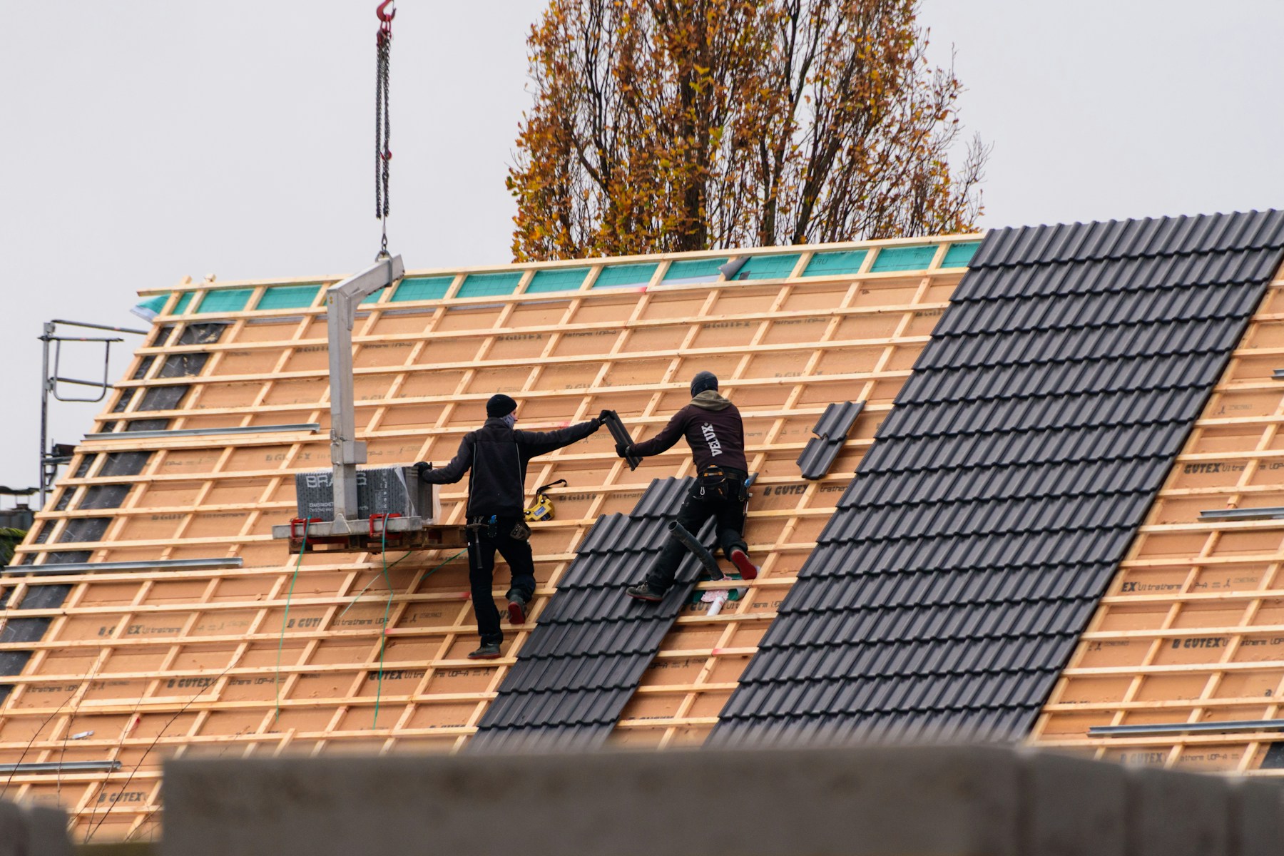 Dachdecker bei der fachgerechten Eindeckung eines Steildachs